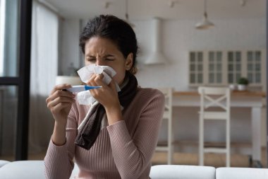 Hasta kadının burnunu kapat, dijital termometre tut.