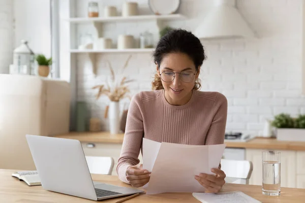 Mujer sonriente en gafas de trabajo con documentos, utilizando el ordenador portátil — Foto de Stock