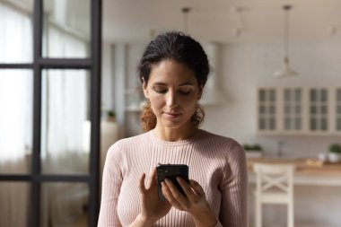 Akıllı telefon ekranına, göz gezdirme uygulamalarına bakan bir kadın.