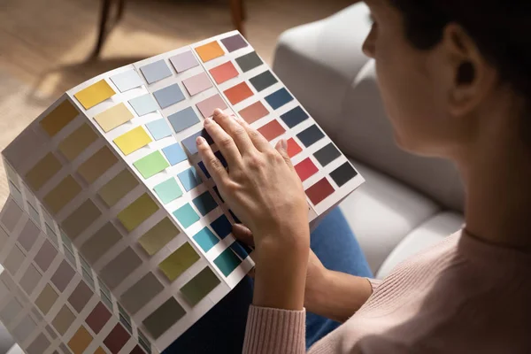 Закрытая женщина выбирает цвет из каталога образцов, концепция обновления — стоковое фото