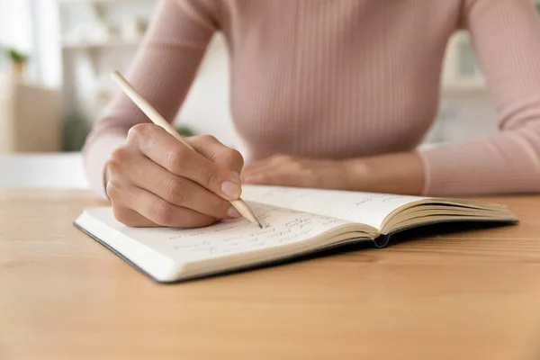 Zbliżenie przycięte przez kobietę robiącą notatki w notatniku — Zdjęcie stockowe