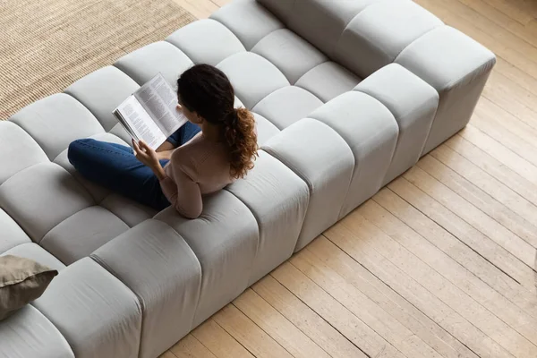 Top view young woman reading book, relaxing on cozy couch — Stock Photo, Image