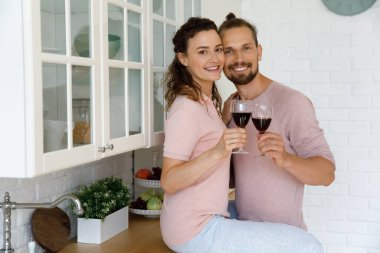 Mutlu milenyum çifti, genç karı koca kırmızı şarap içiyor.