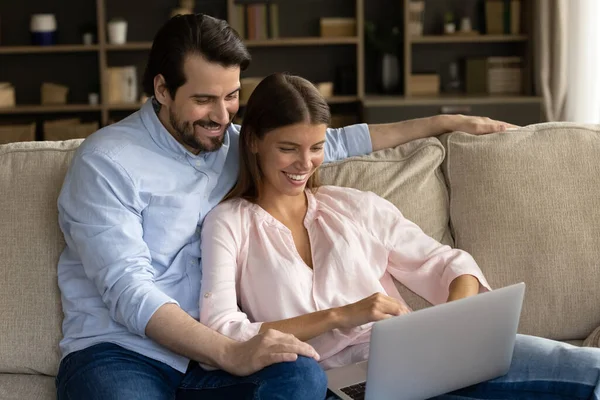 Glückliches fröhliches Millennial-Paar schaut Video, Film auf Laptop-Computer — Stockfoto