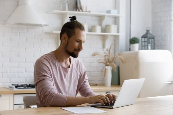 Focalizzato dipendente freelance millenario uomo che lavora al progetto al computer portatile — Foto Stock