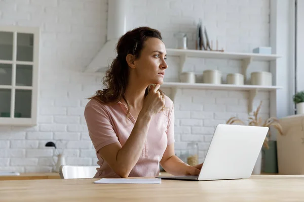 Seriöse freie Mitarbeiterin, die von zu Hause aus am Laptop arbeitet — Stockfoto