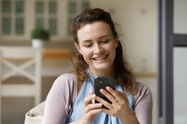 Feliz millennial usuario de teléfonos celulares leyendo mensaje de texto con buenas noticias —  Fotos de Stock