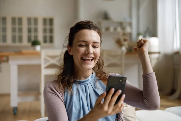 Happy surprised smartphone user receiving amazing good news on smartphone — Stock Photo, Image