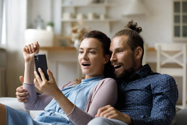 Ενθουσιασμένος έκπληκτος χιλιετή χρονολόγηση ζευγάρι να πάρει απροσδόκητη είδηση στο smartphone — Φωτογραφία Αρχείου