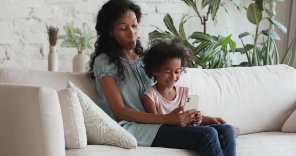 Femeie africană fiica ei deține smartphone-ul având aplicație distractivă — Videoclip de stoc