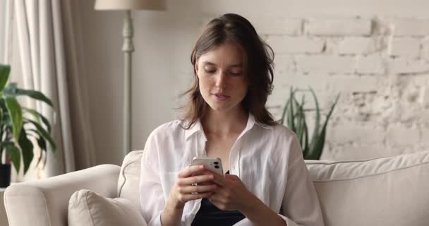 Młoda kobieta trzyma telefon komórkowy czytać dobre wieści czuje się uradowany — Wideo stockowe