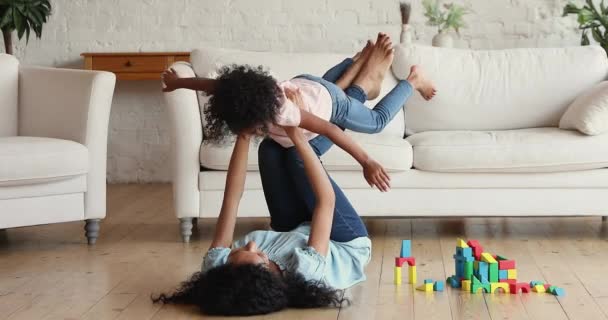 Молодая африканская мама и маленькая дочь играют дома — стоковое видео