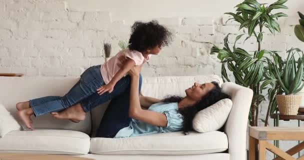 アフリカの母親リフトオン彼女の娘楽しみます遊び時間室内 — ストック動画