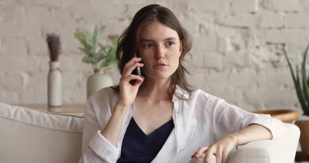 Adolescente menina sentar no sofá fala no telefone inteligente — Vídeo de Stock