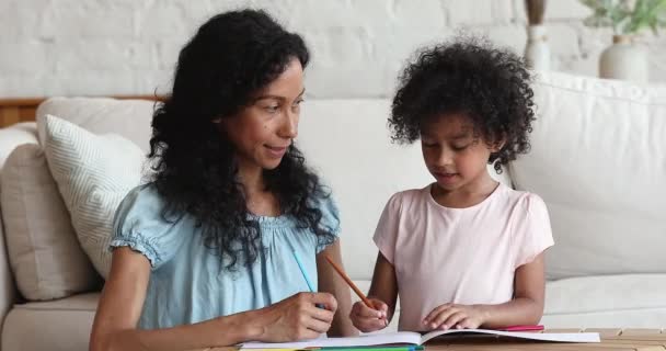 Afrikalı anne ve kız çizim defterinde kalemlerle birlikte çiziyorlar. — Stok video