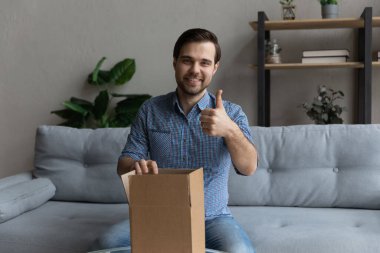 Genç adam sipariş edilmiş malların olduğu paketi açar.