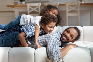 Afrikalı çocuklar babalarının üzerine yığılmış kanepede yatıyorlardı.