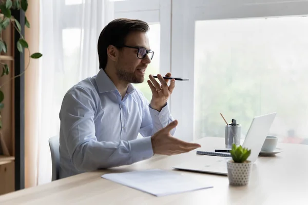 Businessman sit at desk talking to client on speakerphone — Stock Photo, Image