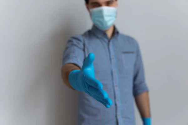 Man in facemask protective gloves stretch out arm for handshake — Stock Photo, Image
