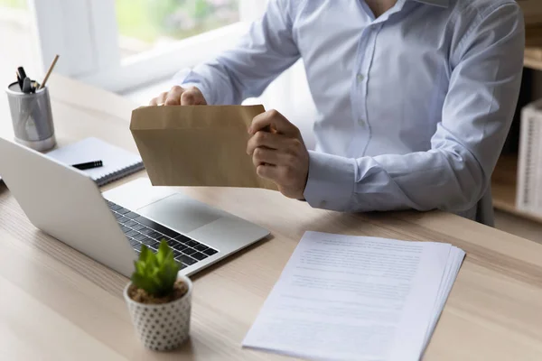 Closeup view man sit at desk takes letter from envelope — Stock Photo, Image