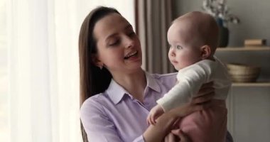 Sevimli bebek, gülümseyen anneye sarıl, yüzüne dokun.