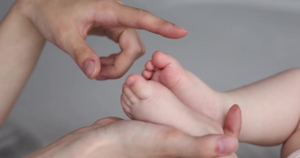 Closeup mom hand caress chubby bare toes of newborn infant — Stock Video