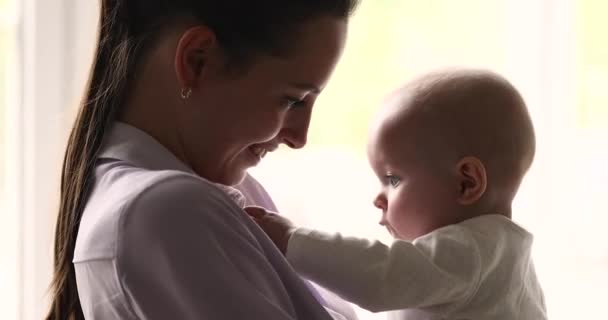 Jovem do sexo feminino desfrutar maternidade segurando doce bebê minúsculo nos braços — Vídeo de Stock