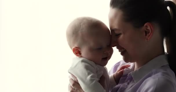 Nahaufnahme einer unbeschwerten, glücklichen Mutter und eines Babys, die drinnen spielen — Stockvideo