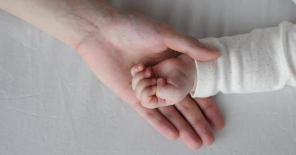 Gros plan affectueux maman main caresse paume du bébé endormi — Video
