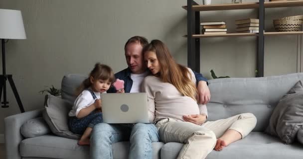 Expectant mother father toddler girl do shopping online on laptop — Stock Video