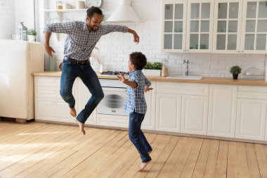 Afrikalı baba ve küçük oğlu mutfakta atlayıp eğleniyorlar.