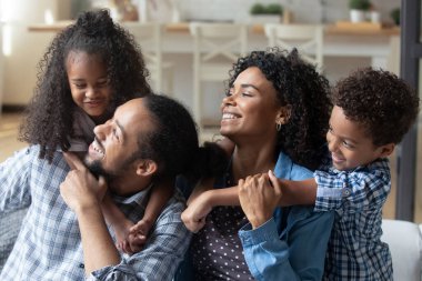 Afrikalı çift ve çocuklar evdeki kanepede oturuyorlar.