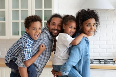 Mutlu çocuklar kameraya bakıp gülümsüyor.