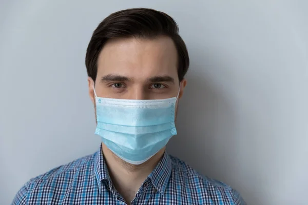 Man wear face mask looking at camera posing indoor