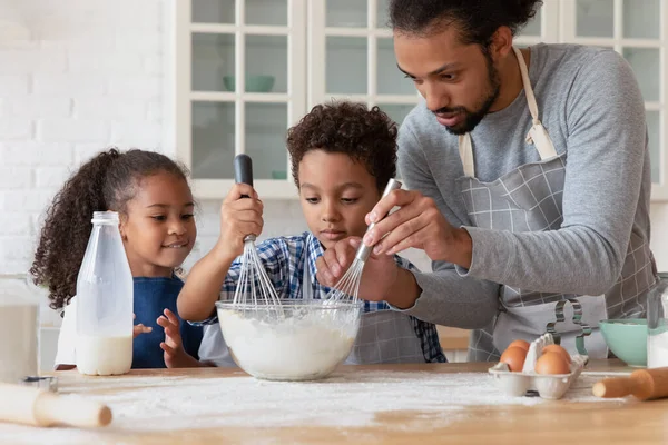 Liebender afrikanischer Papa bringt Kindern Kochen in der Küche bei — Stockfoto