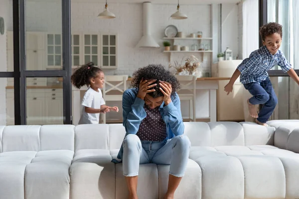 Mère souffre de maux de tête dus à des enfants bruyants qui courent partout — Photo