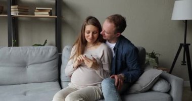 Genç çift internet alışverişinde akıllı telefon kullanarak çocuk bekliyor.