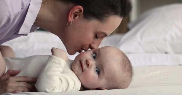 Gelukkig mama verwennen baby fluisteren woorden van liefde op oor — Stockvideo