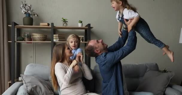 Lycklig far gravid mor son dotter förskolebarn spelar på soffan — Stockvideo