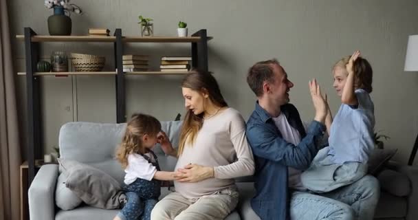 Vänliga familj föräldrar barn tillbringar helgen hemma leka prata — Stockvideo