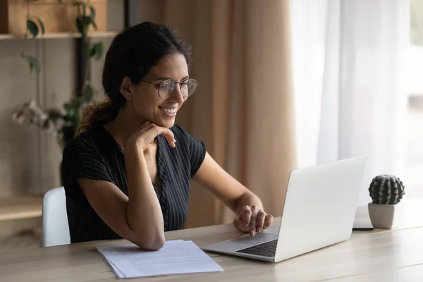 Leende latinamerikansk kvinna arbetar online på datorn hemma — Stockfoto