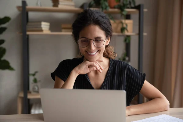 Mujer hispana sonriente trabaja en línea en laptop — Foto de Stock