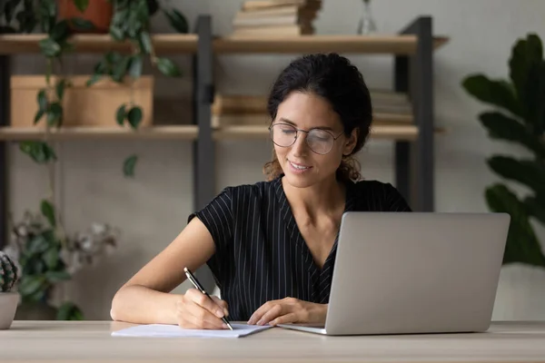 Joven mujer latina escribir a mano trabajando en línea en la computadora — Foto de Stock