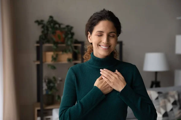 Happy Latin woman hold hands on heart feeling grateful — Stock Photo, Image