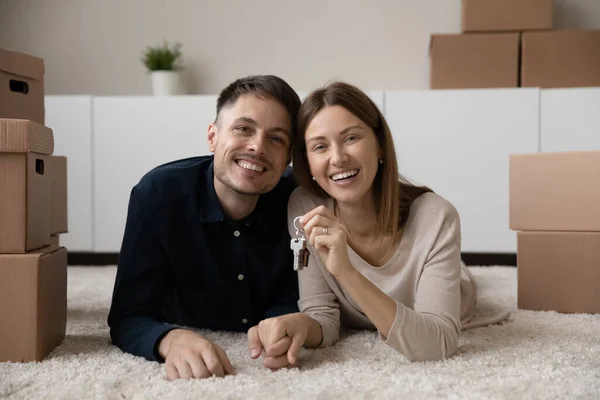 Retrato de jóvenes propietarios felices mostrando las llaves del apartamento. — Foto de Stock