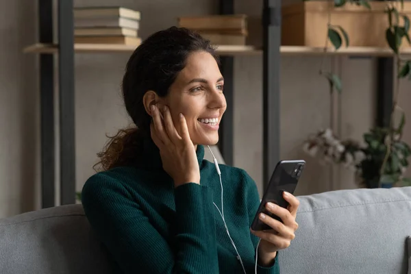 Smiling Hispanic woman listen to music on cell — Stock Photo, Image