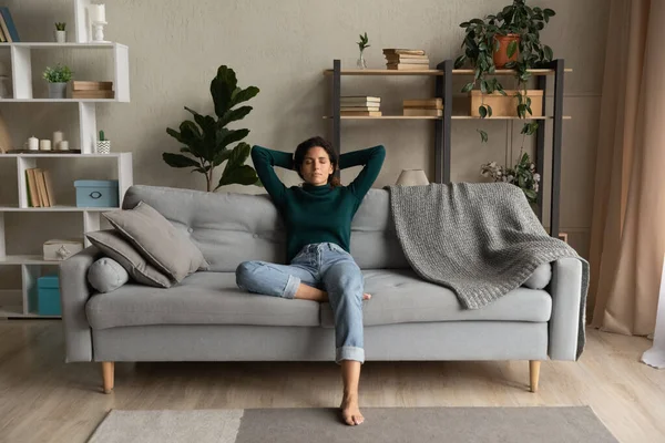 Calm Latino woman relax on sofa breathe fresh air — Stock Photo, Image