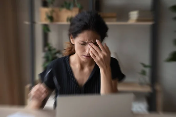 Zieke Spaanse vrouw lijdt aan duizeligheid werken op laptop — Stockfoto