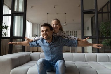 Mutlu Kafkasyalı baba. Domuzcuk 8 'li yaşlarda kızını destekliyor. Uçuyormuş gibi yapıyor.