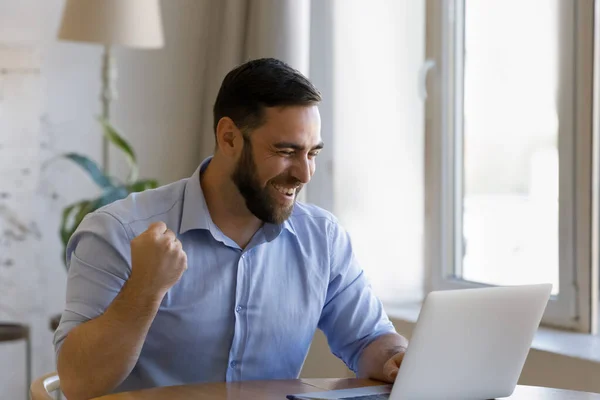 Felice giovane uomo che celebra il successo di internet a casa ufficio. — Foto Stock